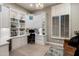 Home office with built-in shelving, ample storage, and natural light from a shuttered window at 6576 E Whispering Mesquite Trl, Scottsdale, AZ 85266