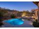 Resort-style pool with stone accents, lush landscaping, and views of the surrounding mountains at 6576 E Whispering Mesquite Trl, Scottsdale, AZ 85266