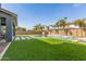 Inviting backyard featuring a refreshing pool, lush artificial grass, and comfortable lounge seating at 7540 E Pampa Ave, Mesa, AZ 85212