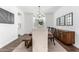 Bright dining area with a large wooden table, white chairs, and modern chandelier, with access to the kitchen at 7540 E Pampa Ave, Mesa, AZ 85212