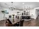 Open-concept kitchen and dining area featuring white cabinets, stainless steel appliances, and pendant lighting at 7540 E Pampa Ave, Mesa, AZ 85212