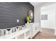 Hallway featuring a decorative shiplap wall, bench, and white storage cabinets at 7540 E Pampa Ave, Mesa, AZ 85212