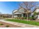 Charming two-story home with a covered porch, lush green lawn, and attractive landscaping at 7540 E Pampa Ave, Mesa, AZ 85212