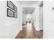 Bright hallway with wood-look tile flooring, white walls, and decorative framed pictures at 7540 E Pampa Ave, Mesa, AZ 85212