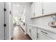 This kitchen features white cabinets and drawers with black pulls with wood floors at 7540 E Pampa Ave, Mesa, AZ 85212