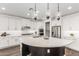 This kitchen features white cabinets, stainless steel appliances, and a large island with pendant lighting above it at 7540 E Pampa Ave, Mesa, AZ 85212