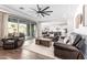 Cozy living room with backyard view featuring leather furniture, wood floors, and an open layout to the kitchen at 7540 E Pampa Ave, Mesa, AZ 85212