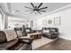 Open-concept living room showcasing dark wood floors, leather furniture, and a view of the modern white kitchen at 7540 E Pampa Ave, Mesa, AZ 85212