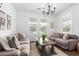 Cozy living room with neutral-toned sofas, a wooden coffee table, and plantation shutters at 7540 E Pampa Ave, Mesa, AZ 85212