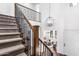 A staircase with carpet, wood railing, and metal balusters leads to the upper level of the home at 7540 E Pampa Ave, Mesa, AZ 85212