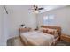 Staged bedroom with tile flooring, ceiling fan, natural light, and modern, minimalist decor at 7769 W Bonitos Dr, Phoenix, AZ 85035