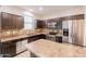 Well-equipped kitchen with stainless steel appliances, dark cabinets, tile backsplash, and breakfast bar at 7769 W Bonitos Dr, Phoenix, AZ 85035