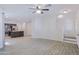 Open-concept living room features tile flooring, ceiling fan, and staircase to the upper level at 7769 W Bonitos Dr, Phoenix, AZ 85035