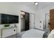 A well-lit bedroom featuring a ceiling fan, TV, closet and modern decor at 8319 E Columbus Ave, Scottsdale, AZ 85251