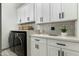 Well-organized laundry room with white cabinets, modern appliances, and stylish tile flooring at 8319 E Columbus Ave, Scottsdale, AZ 85251