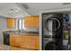 Kitchen sink featuring wooden cabinets, granite countertops, and stainless steel washer/dryer stack at 9125 E Purdue Ave # 214, Scottsdale, AZ 85258