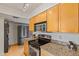 Kitchen featuring wooden cabinets, granite countertops, and stainless steel appliances at 9125 E Purdue Ave # 214, Scottsdale, AZ 85258