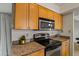 Kitchen featuring wooden cabinets, granite countertops, and stainless steel appliances at 9125 E Purdue Ave # 214, Scottsdale, AZ 85258