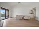 Bright living room featuring a glass coffee table, neutral furniture, and sliding glass doors to patio at 9125 E Purdue Ave # 214, Scottsdale, AZ 85258