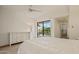 This bright main bedroom features a balcony and white furniture at 9125 E Purdue Ave # 214, Scottsdale, AZ 85258