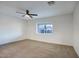 An empty carpeted room with a window and a fan at 918 W Carmen St, Tempe, AZ 85283