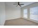 A bedroom with neutral carpet and two windows at 918 W Carmen St, Tempe, AZ 85283