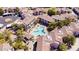 Aerial view of community highlighting common pool with mature trees, shade structures, and nearby residential buildings at 9455 E Raintree Dr # 2020, Scottsdale, AZ 85260