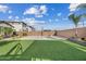 Large backyard with artificial turf, privacy wall, desert landscaping and a basketball court at 10713 E Tesla Ave, Mesa, AZ 85212