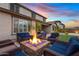 Backyard with a fire pit surrounded by comfortable seating, a lush lawn, and an outdoor dining area at 10713 E Tesla Ave, Mesa, AZ 85212