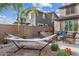Backyard features a hammock, seating around a fire pit, desert landscaping and block wall at 10713 E Tesla Ave, Mesa, AZ 85212