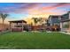 Backyard featuring a well-maintained lawn, an outdoor gazebo with a hot tub, and comfortable patio furniture at 10713 E Tesla Ave, Mesa, AZ 85212