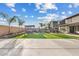 Backyard with artificial turf, outdoor living area, desert landscaping, hot tub and long driveway at 10713 E Tesla Ave, Mesa, AZ 85212