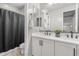 Bathroom features a dual sink vanity with modern fixtures and a separate shower with a sleek black curtain at 10713 E Tesla Ave, Mesa, AZ 85212