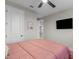 Bedroom features a salmon quilt, fan, and neutral paint, creating a cozy and inviting atmosphere at 10713 E Tesla Ave, Mesa, AZ 85212
