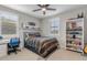 Well-lit bedroom featuring a work desk and shelving creating a harmonious space for rest and productivity at 10713 E Tesla Ave, Mesa, AZ 85212