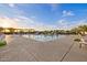 Community pool with a large sun deck, lounge seating, shade structures, and beautifully landscaped surroundings at 10713 E Tesla Ave, Mesa, AZ 85212