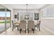 Dining room with gray tufted chairs and a modern chandelier by a large window at 10713 E Tesla Ave, Mesa, AZ 85212