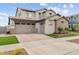 Exterior view of a two-story home with a three-car garage and brick-paved driveway at 10713 E Tesla Ave, Mesa, AZ 85212