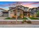 Beautiful two-story home exterior with stone accents, professional landscaping, and a walkway leading to the front porch at 10713 E Tesla Ave, Mesa, AZ 85212