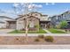 Two-story home with stone accents, a well-manicured lawn, and professional landscaping at 10713 E Tesla Ave, Mesa, AZ 85212