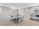 Bright game room features a ping pong table, carpeted floors, and multiple windows for natural light at 10713 E Tesla Ave, Mesa, AZ 85212