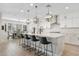 Modern kitchen featuring quartz countertops, pendant lighting, stainless steel appliances, and an adjacent dining area at 10713 E Tesla Ave, Mesa, AZ 85212