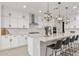 Bright kitchen featuring white cabinets, stainless steel appliances, and a large quartz countertop island with pendant lighting at 10713 E Tesla Ave, Mesa, AZ 85212