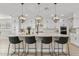 Modern kitchen featuring an island with quartz countertops, pendant lighting, stainless steel appliances, and white cabinets at 10713 E Tesla Ave, Mesa, AZ 85212