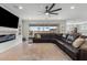Spacious living room with large leather sectional, fireplace, TV, and an open view of the backyard at 10713 E Tesla Ave, Mesa, AZ 85212