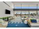 Bright lounge area featuring comfortable seating, a large TV, and floor-to-ceiling windows with an outdoor view at 10713 E Tesla Ave, Mesa, AZ 85212