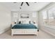 Serene main bedroom showcases plantation shutters, a ceiling fan and an ensuite bathroom at 10713 E Tesla Ave, Mesa, AZ 85212