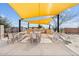 Outdoor kitchen and dining area featuring multiple grills, prep areas, and ample seating under a shade structure at 10713 E Tesla Ave, Mesa, AZ 85212