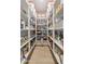 Walk-in pantry featuring open shelving, hardwood floors, and wallpapered accent wall at 10713 E Tesla Ave, Mesa, AZ 85212