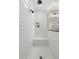Modern shower with sleek white subway tile, a built-in bench, and contemporary fixtures at 10713 E Tesla Ave, Mesa, AZ 85212